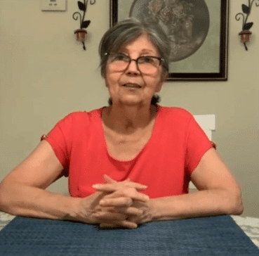 Elderly woman sitting at dining table